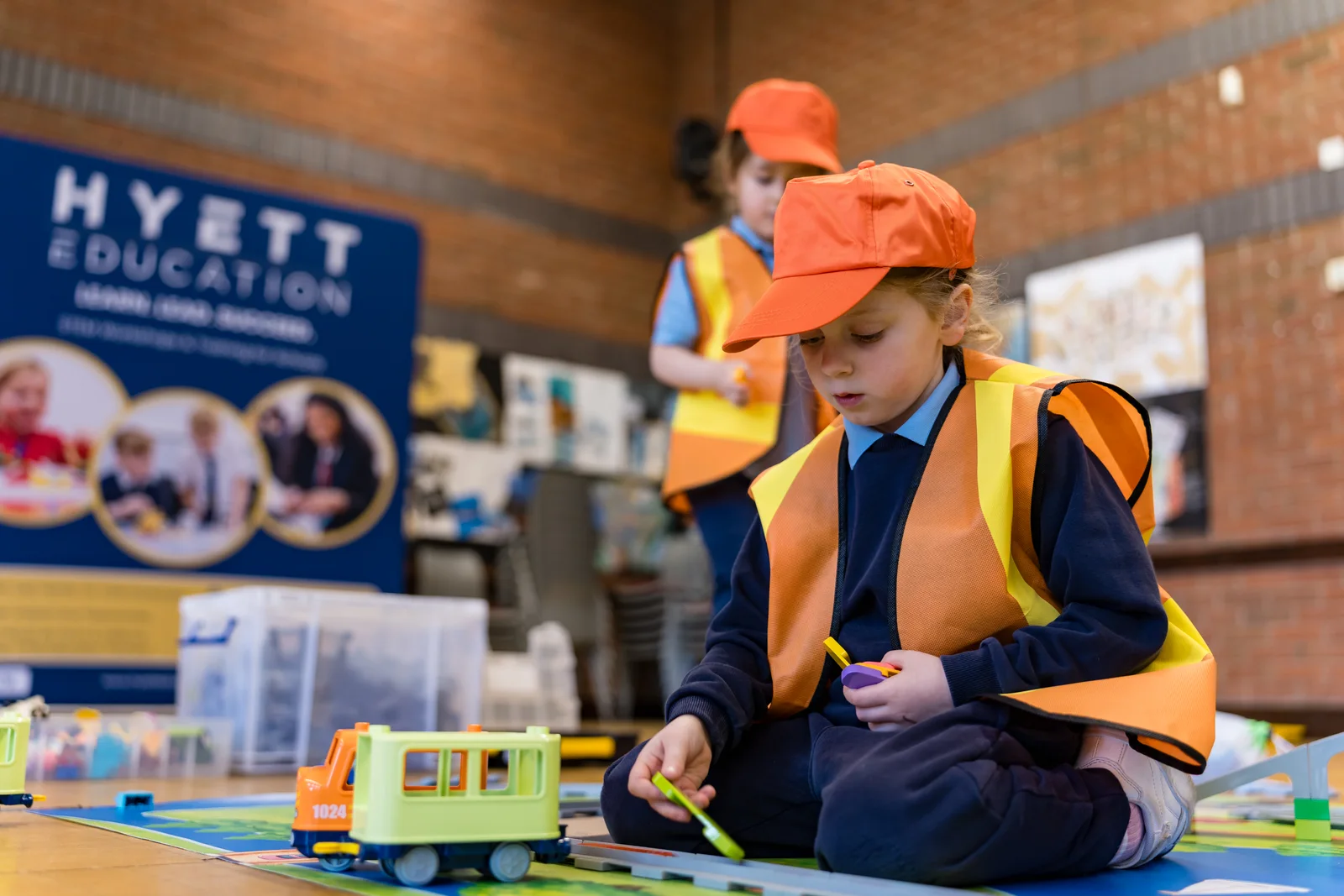 A child building and testing a LEGO DUPLO train track