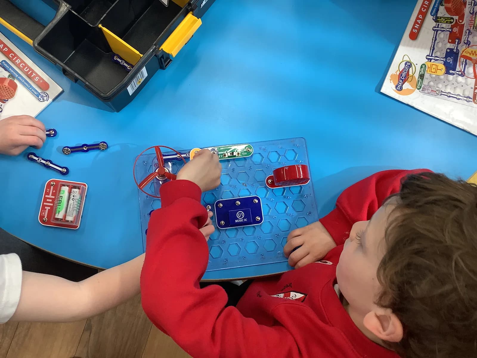 Children connecting components to build a working electrical circuit