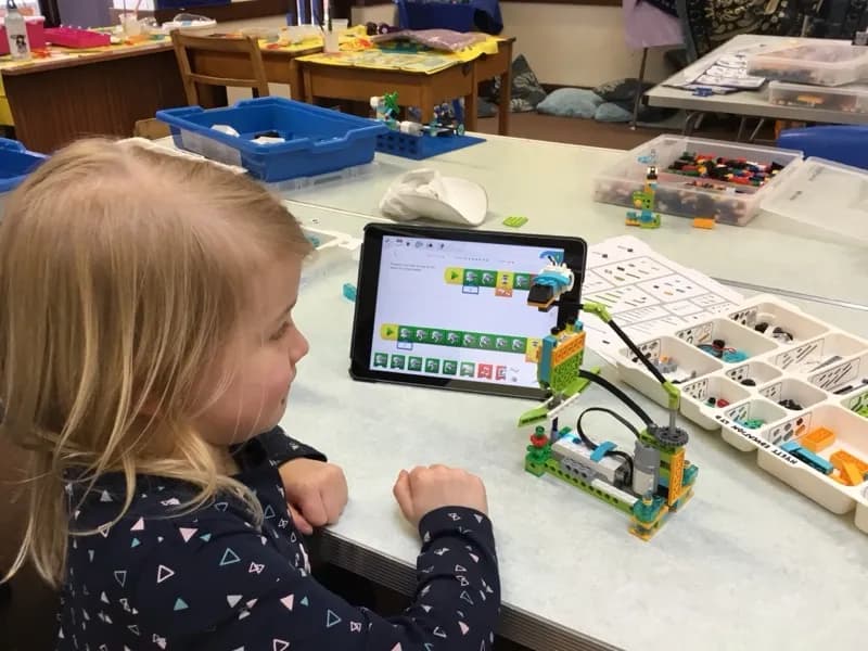 A child programming a LEGO WeDo robot from an iPad